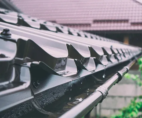 A close-up of newly-installed gutters in the rain.